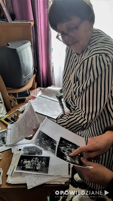 Helena Sokół podczas notacji prezentuje dokumenty i pamiątkowe rodzinne zdjęcia